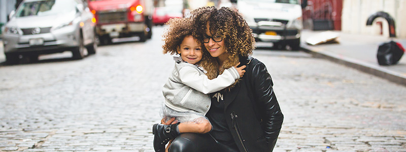 mãe e filha Índigo sorrindo em rua