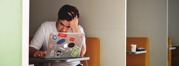 Jovem irritado em frente ao computador, com alto cortisol - burning out