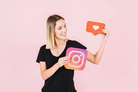 terapeuta com ícone do Instagram e like nas mãos aprendendo a como divulgar o trabalho de terapeuta de forma humanizada