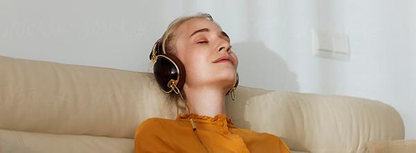 menina fazendo atendimento terapêutico online em casa, no sofá com meditação guiada