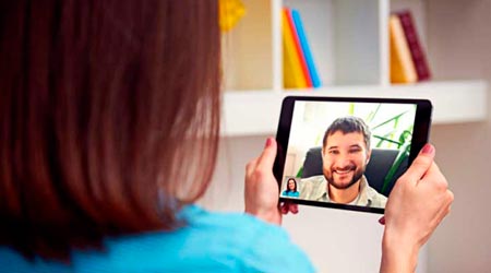 mulher em atendimento terapêutico online com terapeuta por tablet