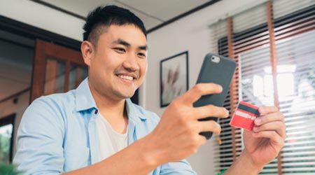 homem com celular e cartão de crédito na mão pagando sua terapia feliz