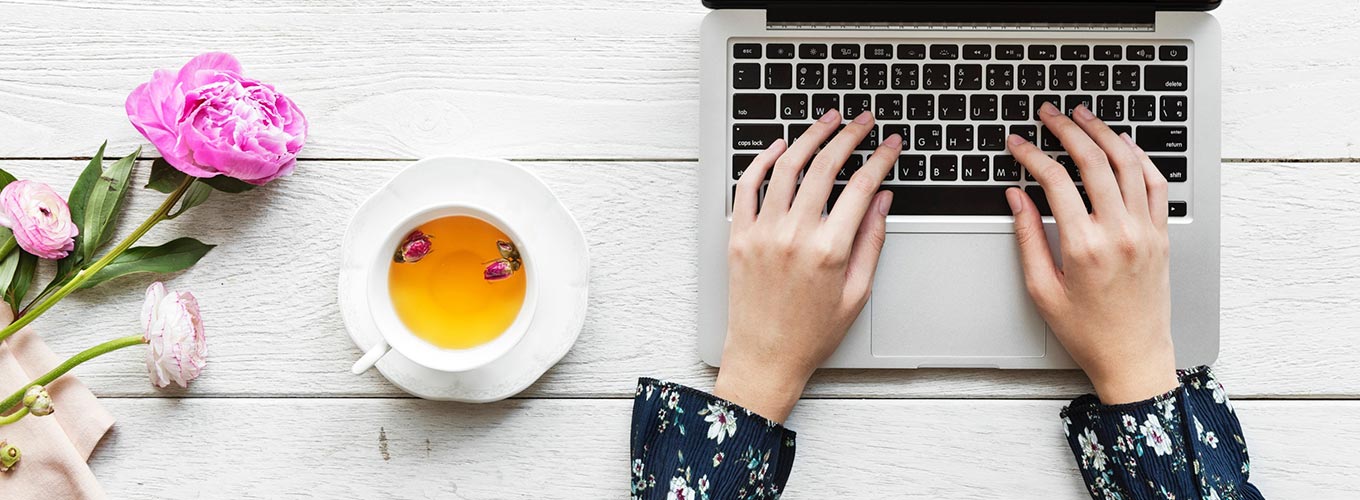 terapeuta em mesa usando laptop lendo dicas para divulgar terapia holística