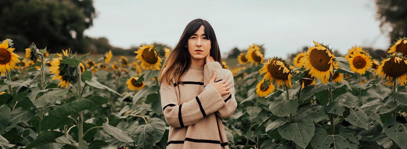 mulher em campo de girassois: foto conceitual para tratamento natural para fibromialgia
