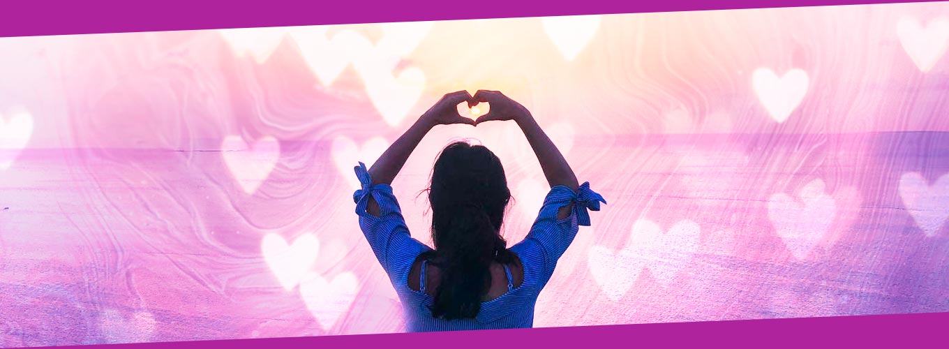 mulher de costas fazendo coração com as mãoes em meditação do amor próprio e autoaceitação