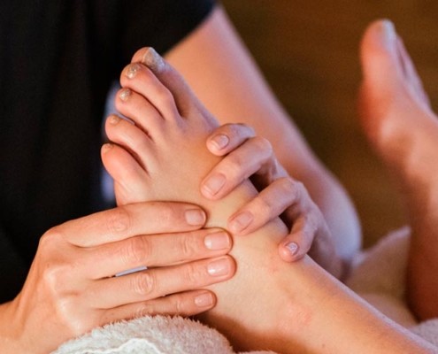 terapeuta fazendo sessão de reflexologia podal