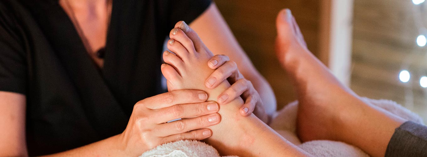 terapeuta fazendo sessão de reflexologia podal